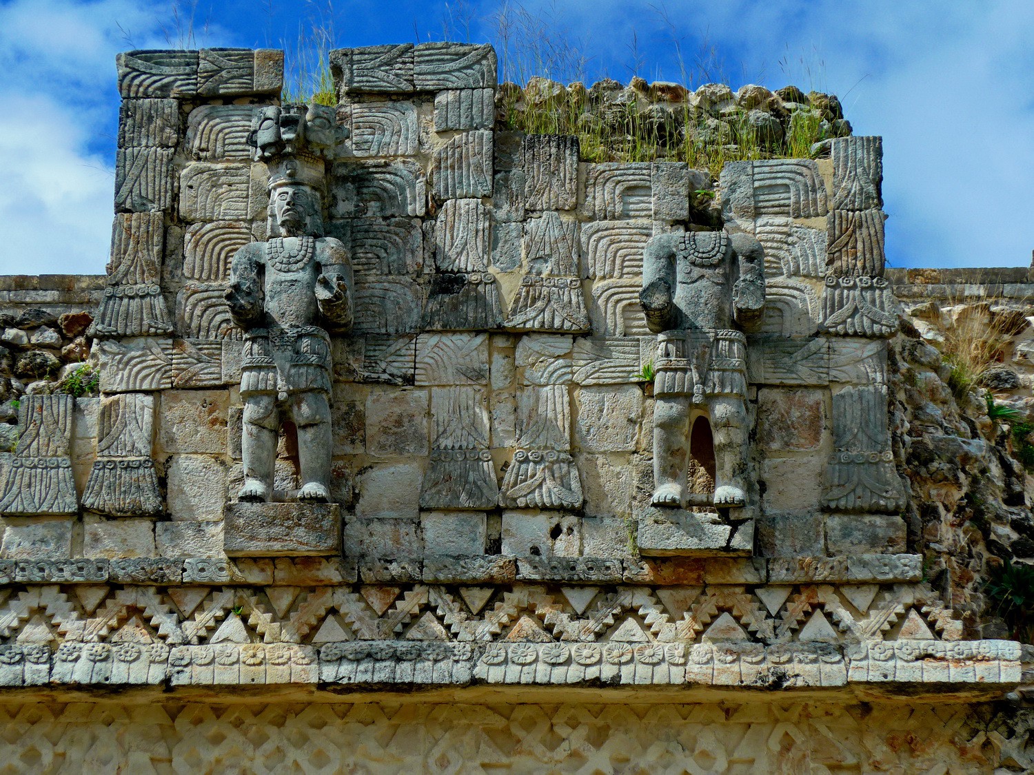 Two male figures in Kabáh - the left one wears a jaguar mask atop his head