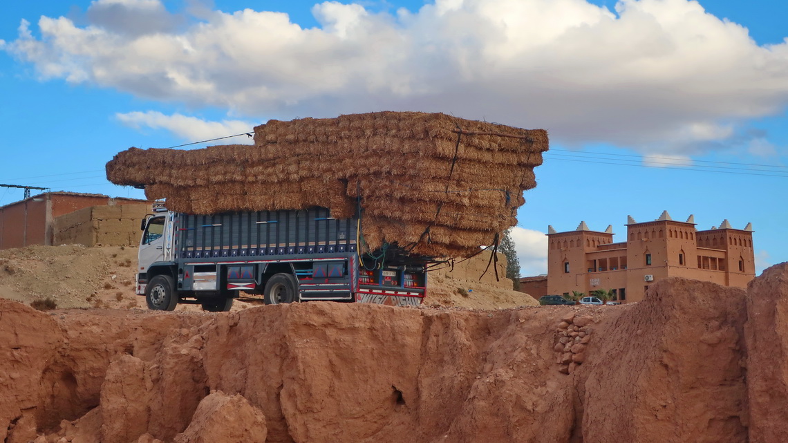 Fully loaded truck with a Kasbah like hotel in Itlouane