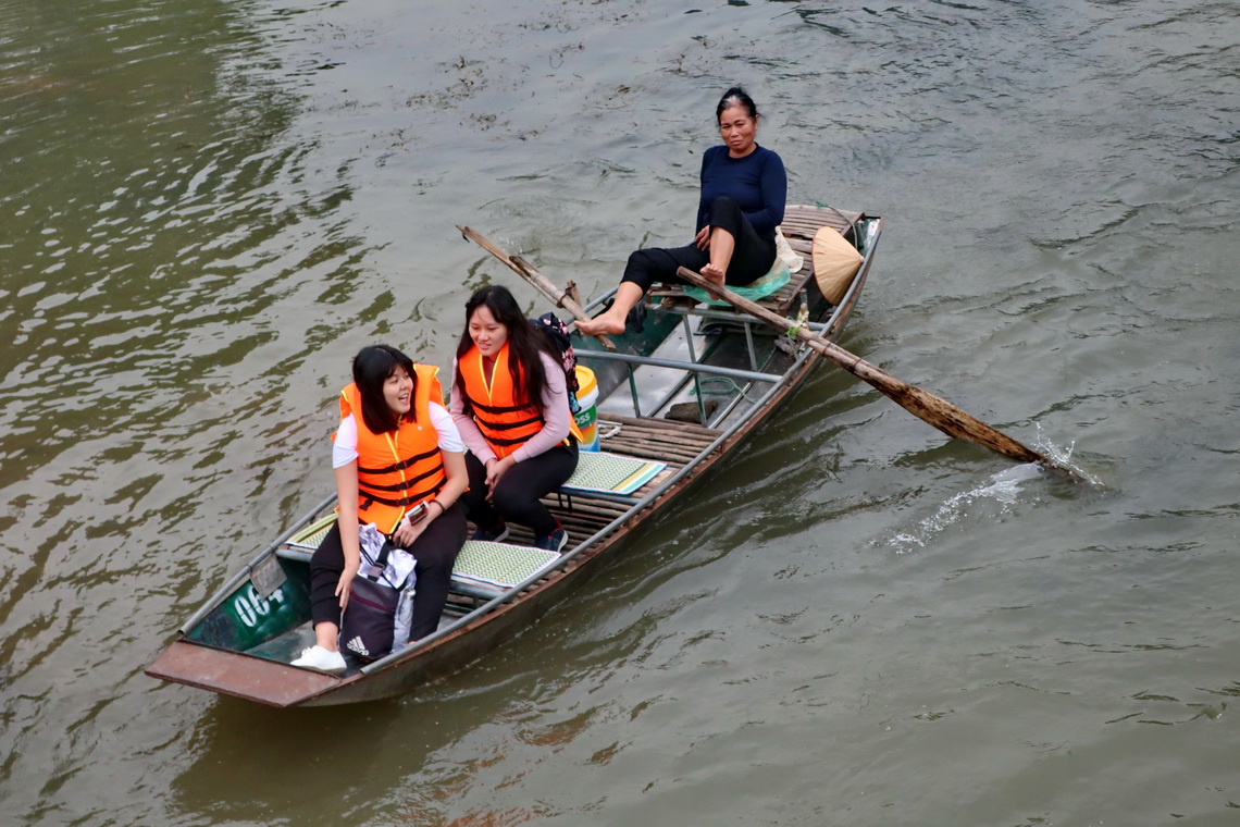 Rowboat on Tam Coc River driven by an elderly Lady with her feet