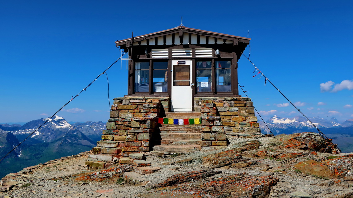 Fire vantage hut with Nepali flags on top of Swiftcurrent Peak