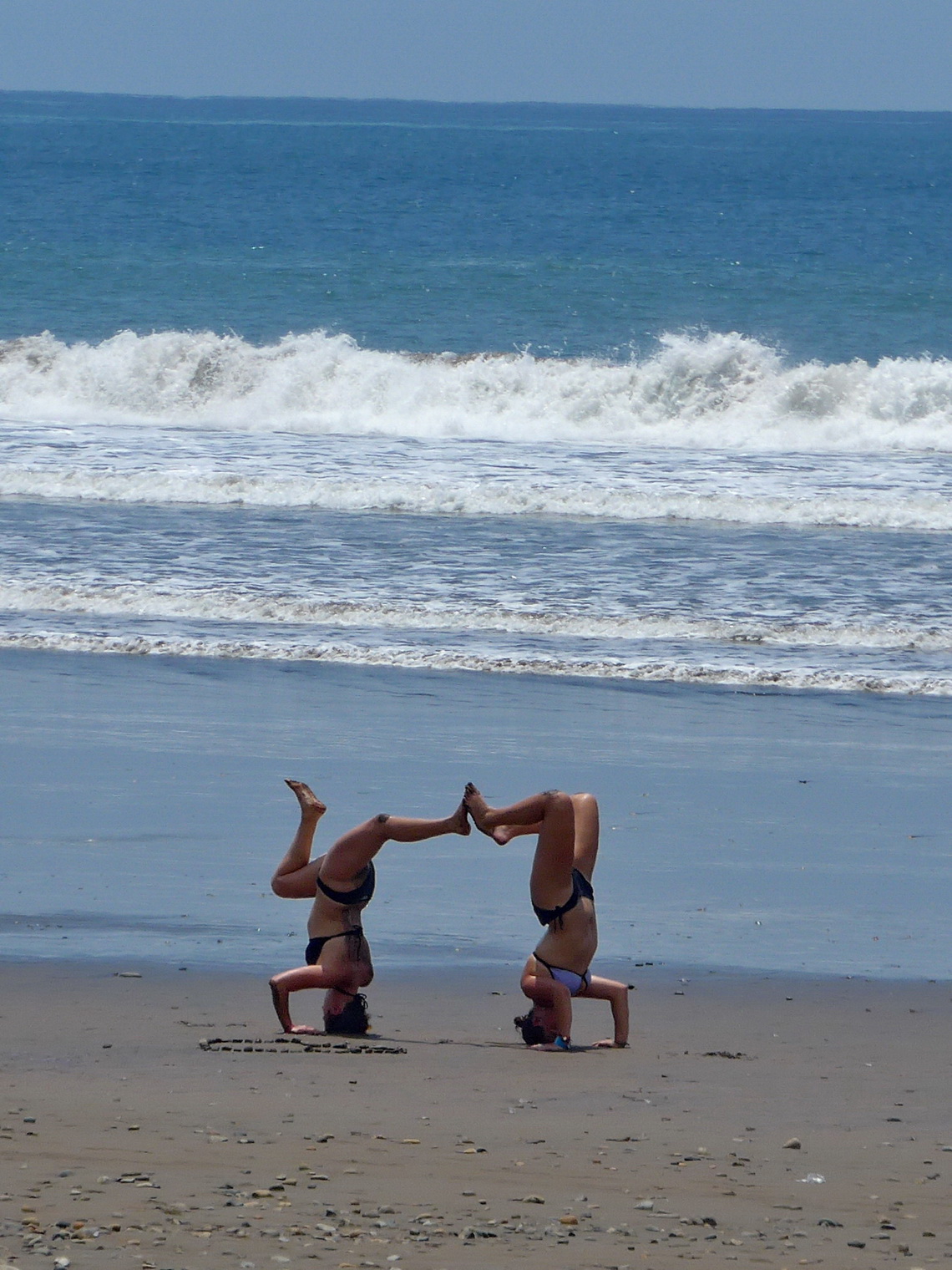 Two girls exercising in front of the Pacific Ocean
