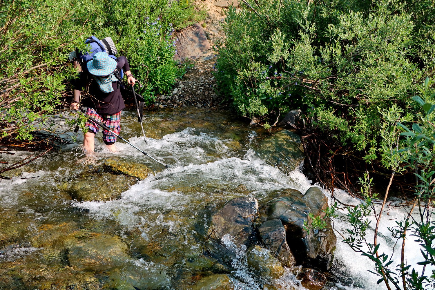 Crossing the stream with a heavy backpack