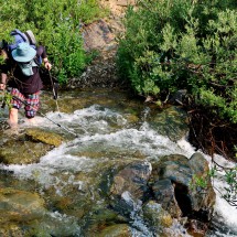 Crossing the stream with a heavy backpack