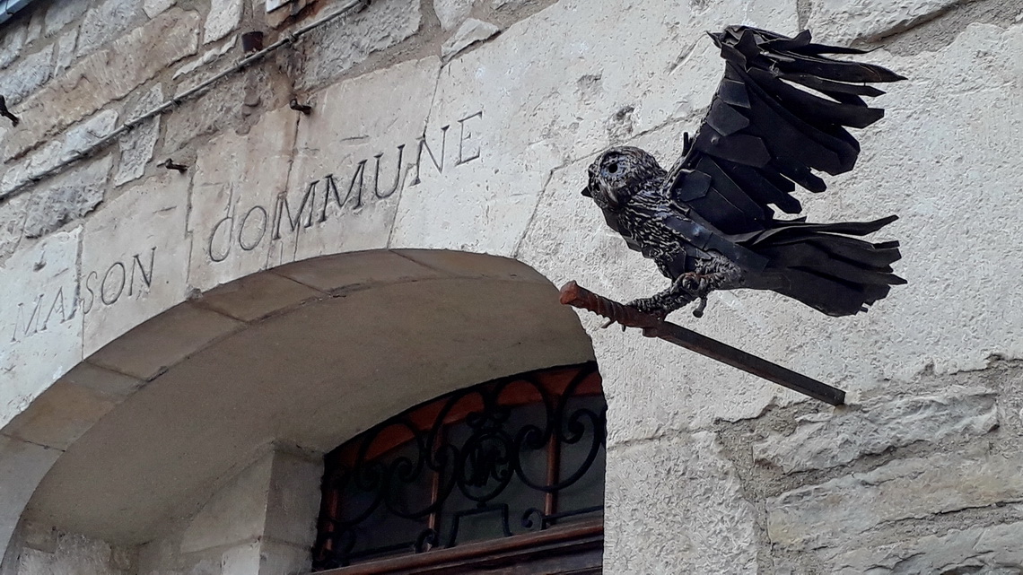 Iron owl on the wall of the town hall of Caylus