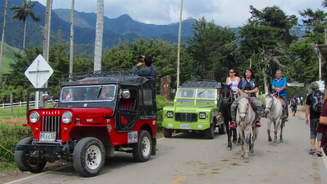 Willys, the most popular car in Colombia on the left with riding tourists on the right