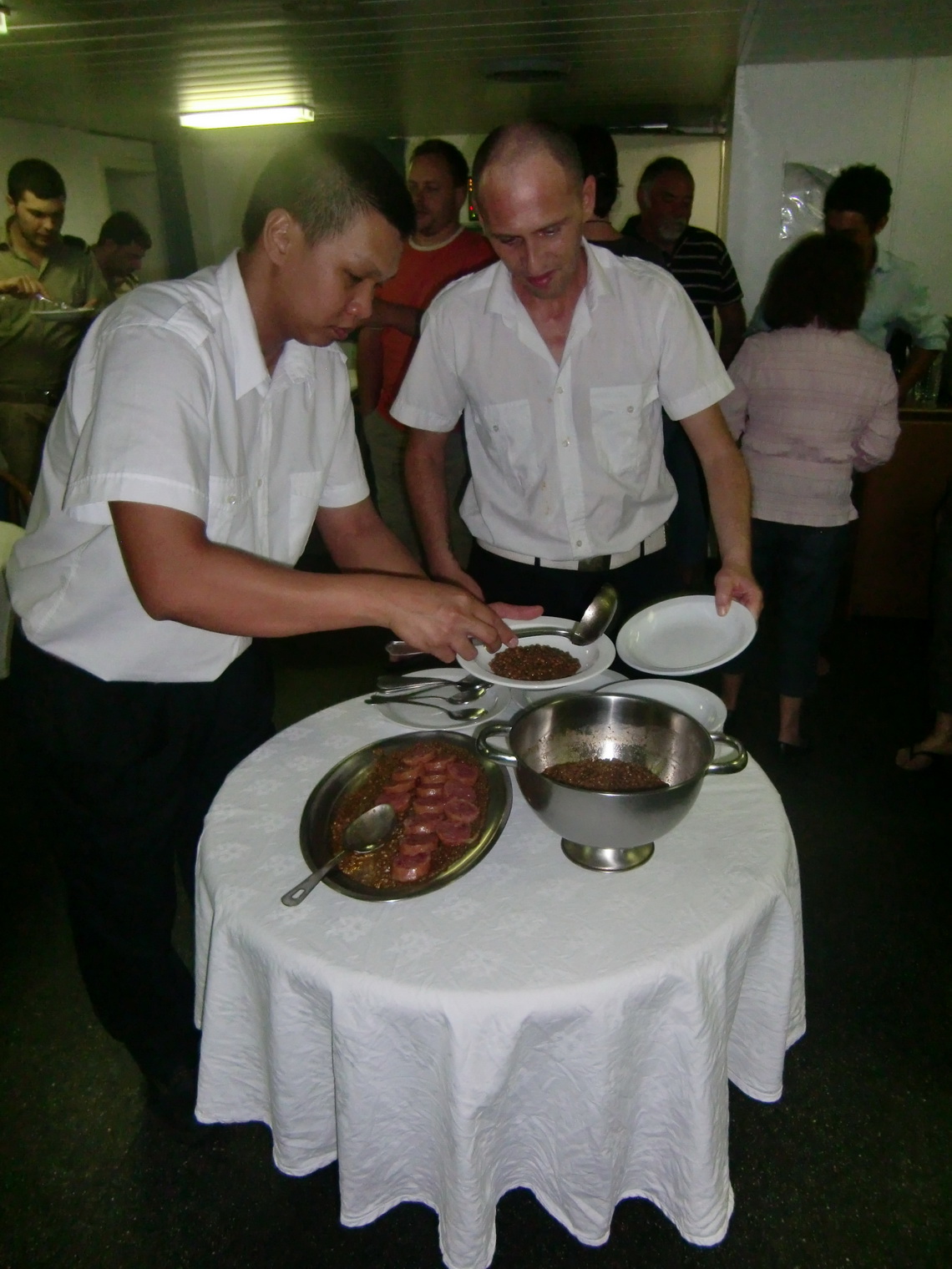 Rumen and Massimo serving lenses with sausages
