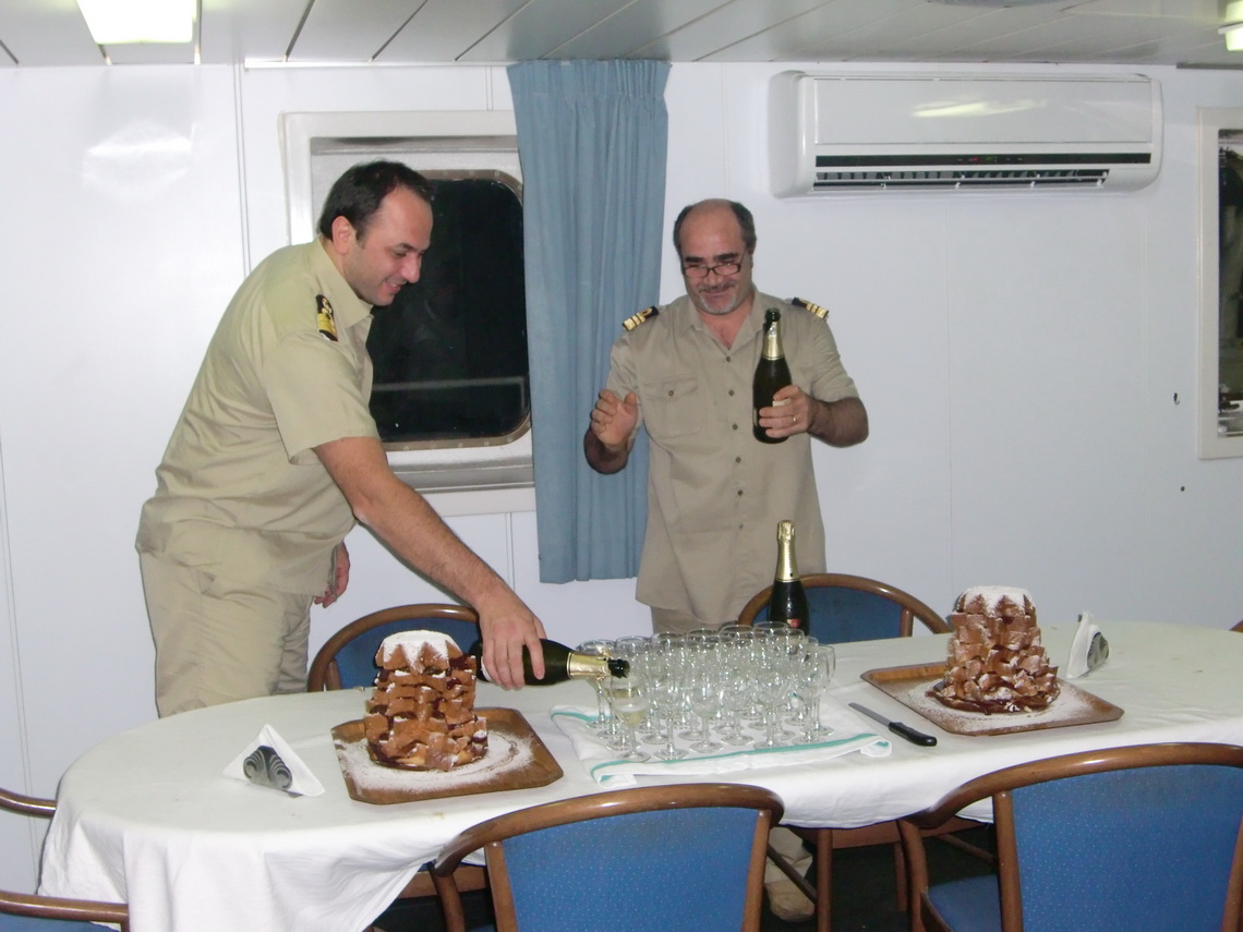 Captain and Director serving champagne